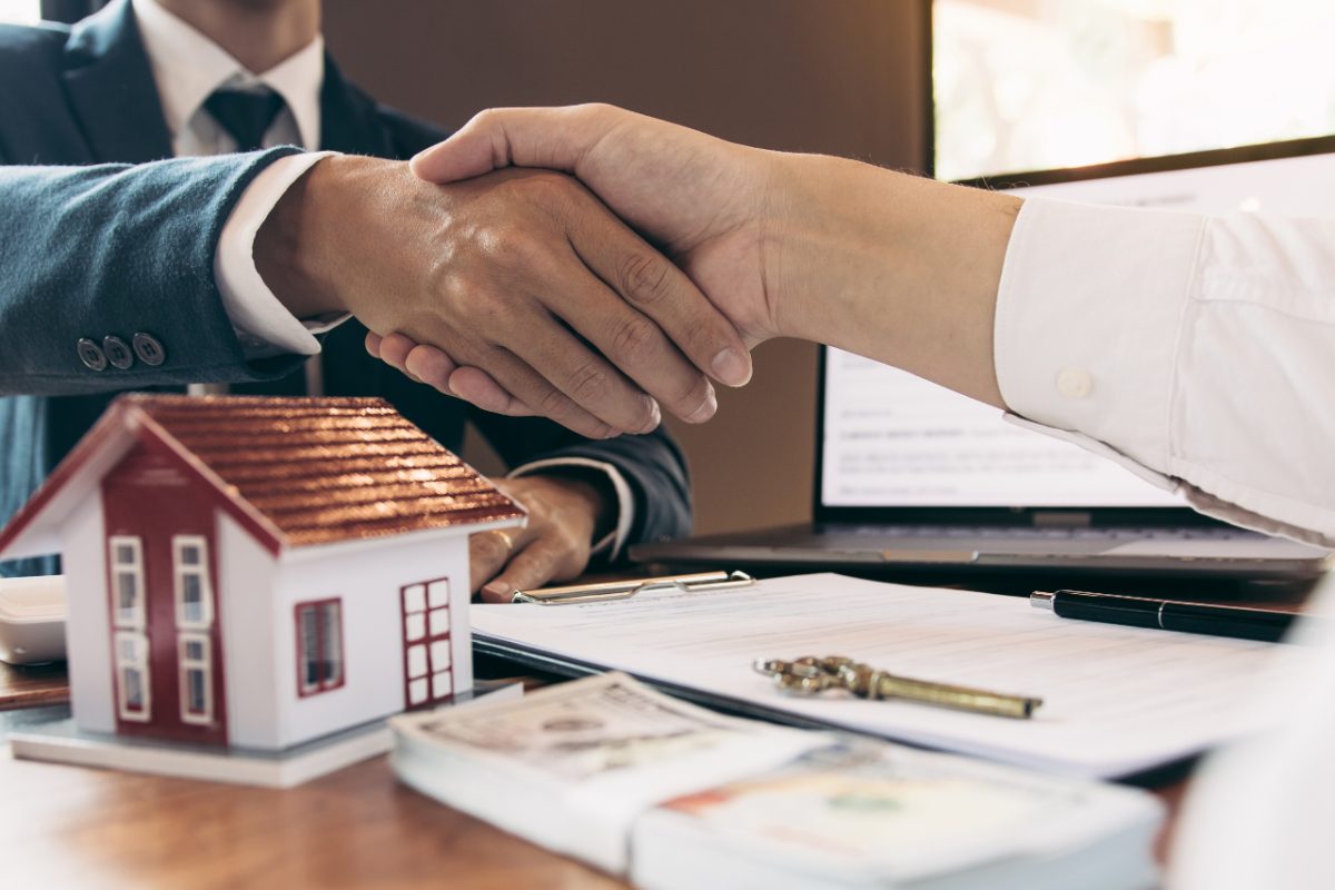 A first-time buyer reviewing rental yields data for Tokyo neighborhoods with a property agent