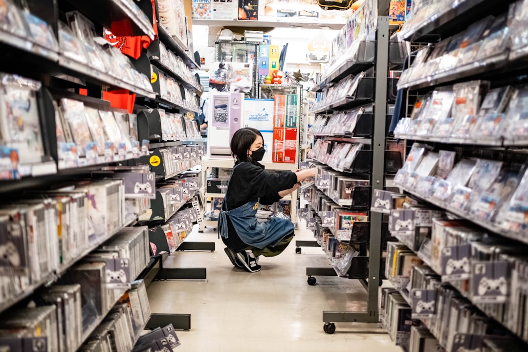 A konbini culture worker restocking fresh food shelves inside a brightly lit Tokyo convenience store at night