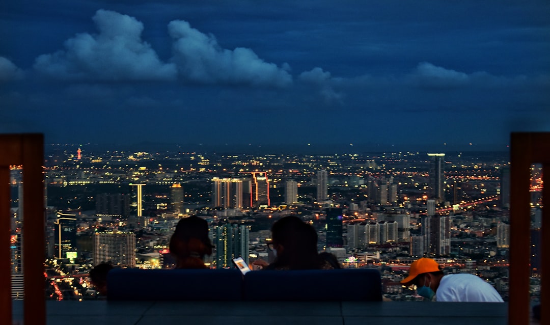 A couple seated at a rooftop bar above Tokyo, enjoying sunset cocktails with a panoramic skyline lounge in the background.
