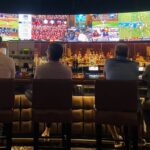 A packed crowd of fans cheering at one of Tokyo's sports bars during a World Cup match