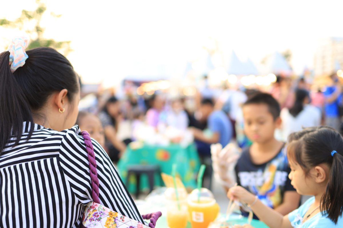 A woman enjoys authentic cuisine at one of the international food festivals held in Tokyo's parks in June.