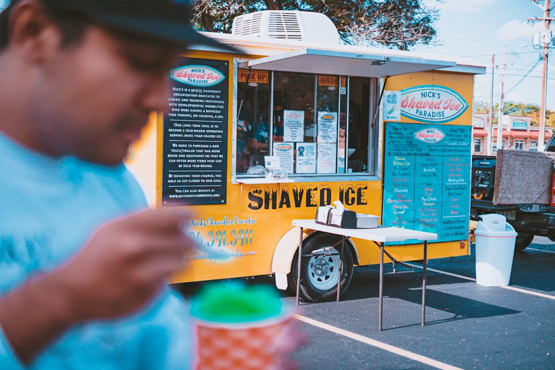 A visitor waits at the counter of a shop, ready to receive a shaved bowl prepared with natural ice and seasonal syrup.
