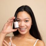 A woman applying lightweight serum as part of her humid skin care morning routine in Tokyo