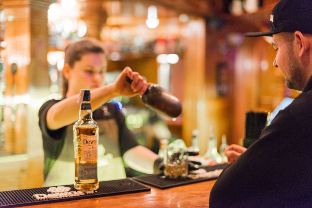A hotel bartender presents a curated Japanese whisky flight on a dark wood counter in Tokyo