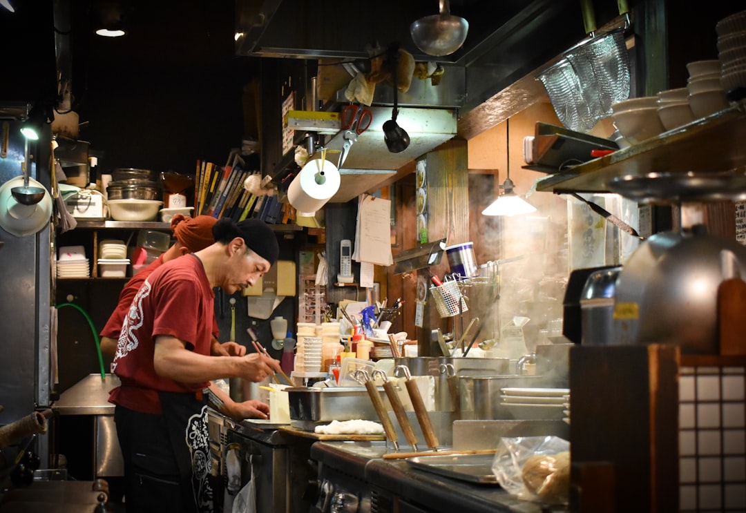 A soba chef carefully slices hand-rolled buckwheat dough in a Tokyo kitchen, preparing cold soba for the lunch service.