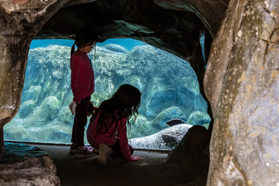 A mother and young child press close to a glowing jellyfish exhibit at one of Tokyo's best Tokyo aquariums for children