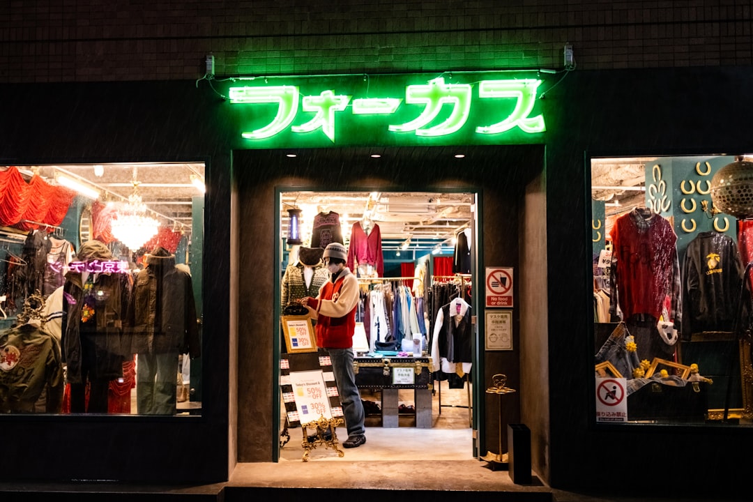 A woman carefully examines natural fibre garments in a Tokyo secondhand wardrobe shop