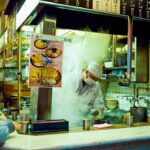 People in a Tokyo soba restaurant, dipping the chilled buckwheat noodles into a ceramic cup of dashi sauce.