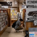 A woman sits quietly in a Tokyo listening bar, experiencing kissa culture through vinyl played on a hi-fi system