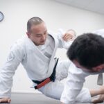 An adult beginner receives English instruction from a sensei at a Tokyo dojo during a karate class