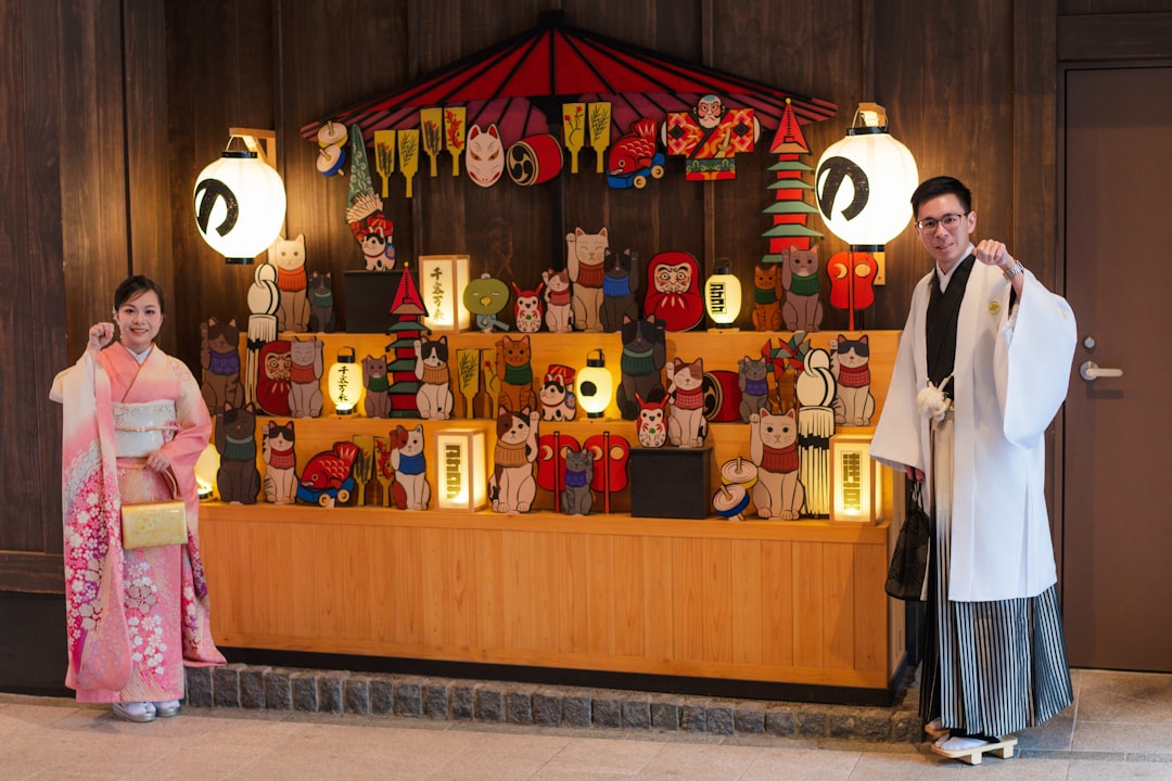 A kimono-dressed host welcomes arriving guests at a Kagurazaka ryokan entrance during the summer Obon season in Tokyo.