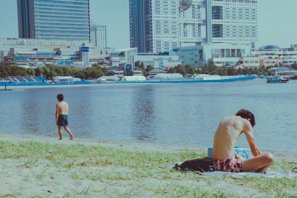 wading into the water at an open water swimming event near Tokyo Bay, with the city skyline visible in the background