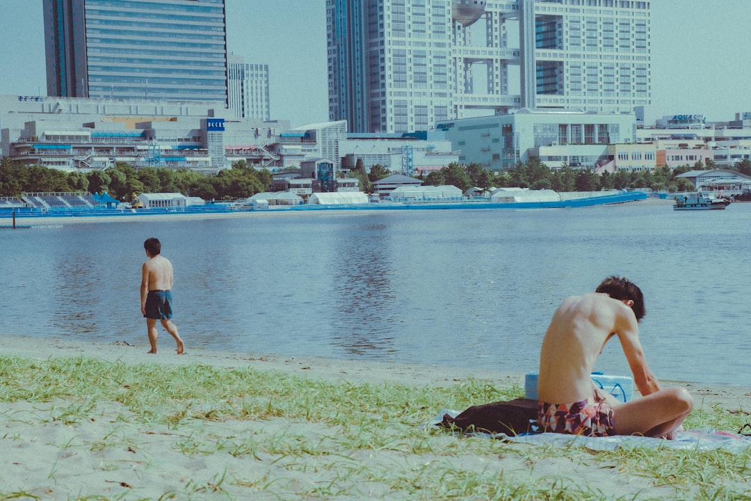 wading into the water at an open water swimming event near Tokyo Bay, with the city skyline visible in the background