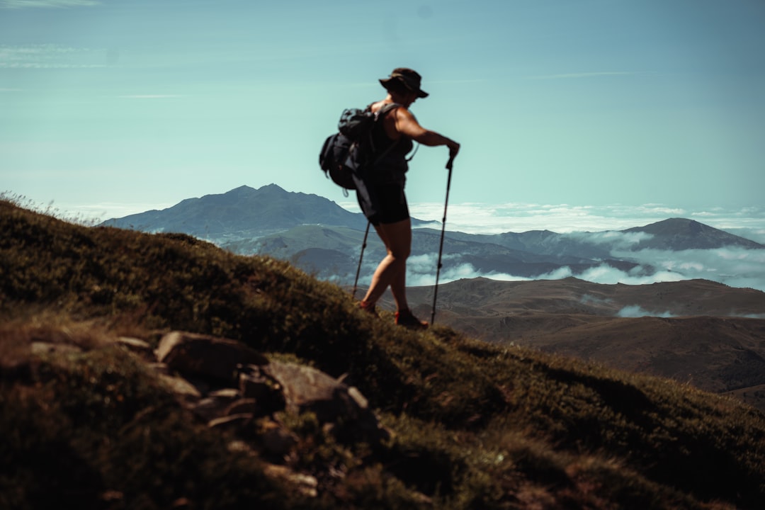 A woman hiker pauses on the Yoshida Trail during Mt Fuji climbing season, with the early morning sky turning pink behind her.
