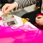 A volunteer helps a woman mend a jacket at a repair café in Tokyo, showing community mending in action.
