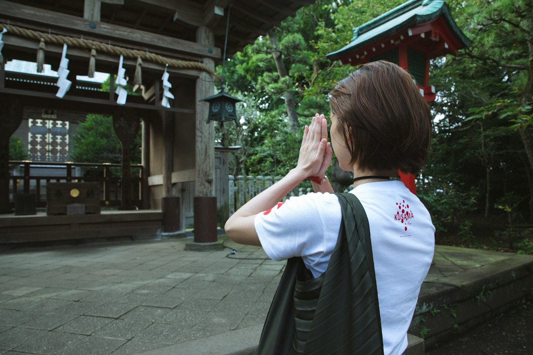 A woman cleans a family gravestone during autumn equinox week at a shitamachi temple in Tokyo