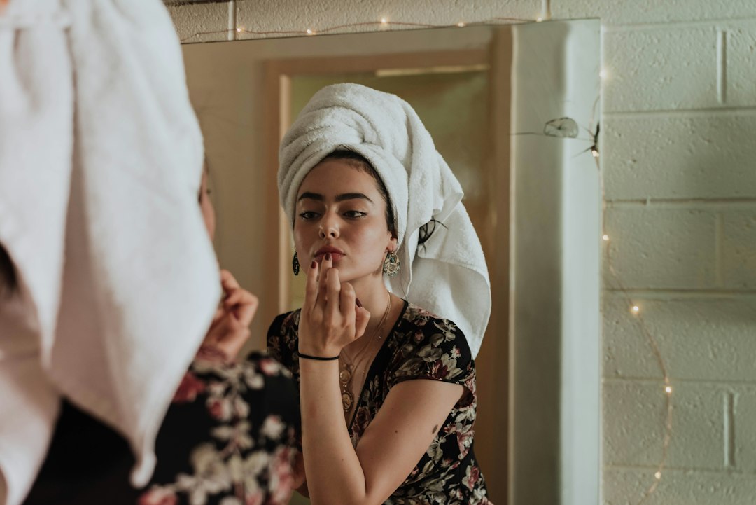 Woman treating dry skin with hydrating lotion in winter